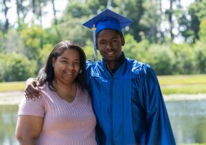 African graduate posing with mother/relative outdoors