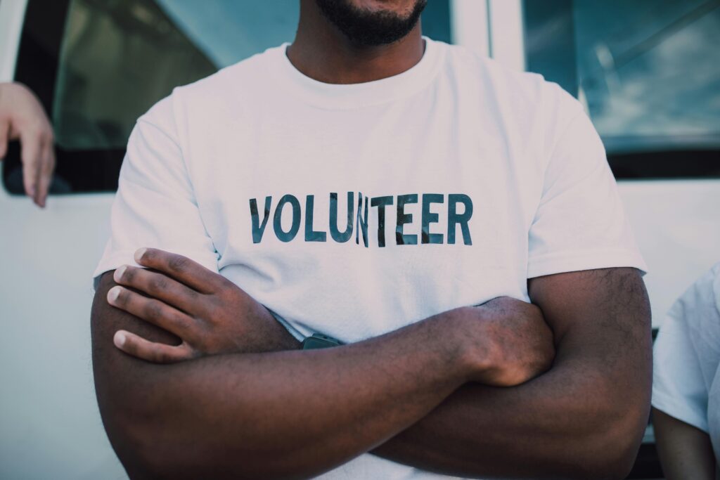 African man with arms crossed wearing a volunteer t-shirt African man with arms crossed wearing a volunteer t-shirt